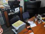 un homme assis à un bureau, entouré d'une pile de papiers