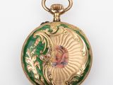 a gold and green pocket watch with a painting on it