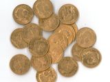 a pile of gold coins sitting on a white surface