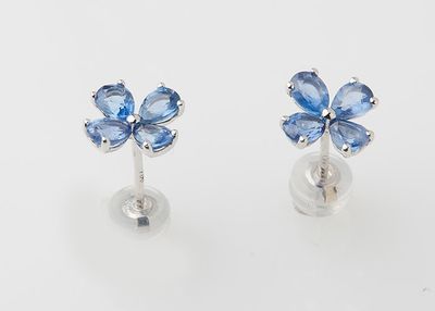 a pair of blue sapphire flower earrings on a white background