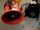 un ventilateur rouge posé par terre à côté d'autres ventilateurs