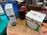 une boîte de pizza posée sur une table à côté d'un carton de sodas