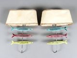 three different colored fish hanging on a hook on the wall