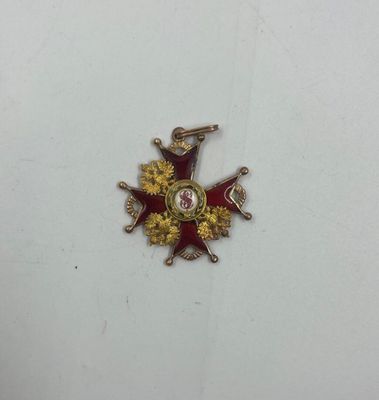 un gros plan d'un insigne posé sur une surface blanche, orné d'une étoile rouge et dorée