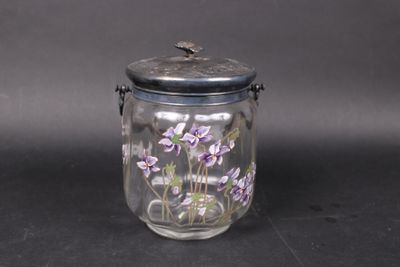 a glass jar with purple flowers in it on a table
