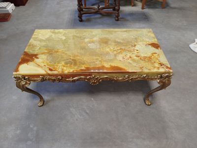 une table basse au plateau en marbre au milieu d'une pièce