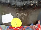 a close up of a vase with a yellow sticker on it