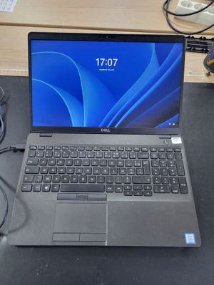 a laptop that is sitting on a desk with a charger attached to it
