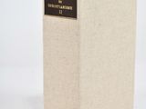 an old book sitting on top of a white table next to a white wall