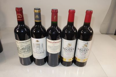 six bottles of red wine are lined up on a counter