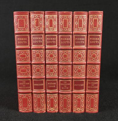 six red books are lined up in a row on a black surface