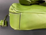 a green purse with a cell phone on top of it