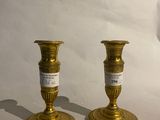 two gold candles that are sitting on a white table