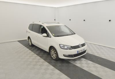 une camionnette blanche garée dans une pièce au sol à carreaux et aux murs blancs