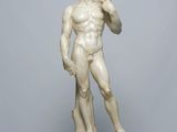 a white marble statue of a man standing on top of a table