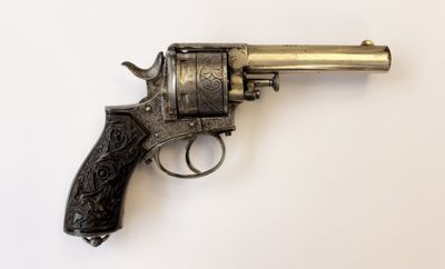 gros plan d'un revolver sur une surface blanche