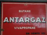 une enseigne rouge portant l'inscription « Antarcaal » sur le côté d'un immeuble