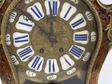a gold clock with blue and white roman numerals on it