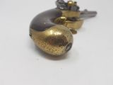 a gold and black object on a white surface