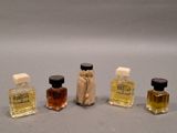 three small bottles of perfume sitting next to each other on a table