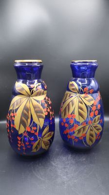 deux vases bleus ornés de motifs dorés, posés sur une table