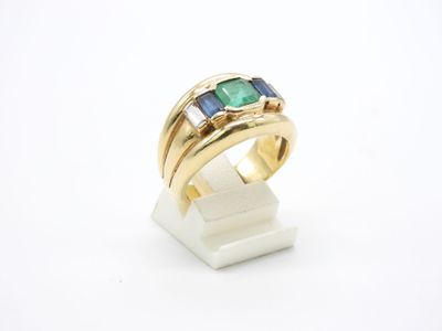 un gros plan d'une bague en or sertie d'une pierre verte et bleue