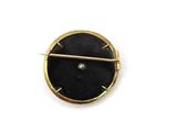 an image of a black and gold pin with a diamond in it
