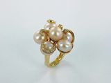 une bague en or ornée de perles et de diamants sur fond blanc