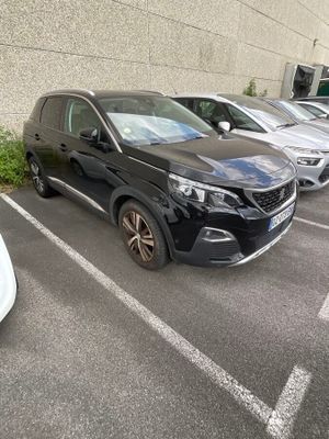 many cars parked in a parking lot next to a building