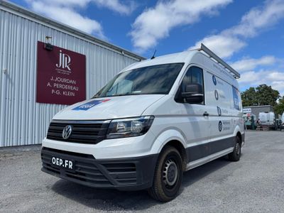 Une camionnette blanche est garée devant un immeuble.