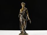 a bronze statue of a woman holding a flower on a marble base