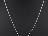 un pendentif en forme de cœur en argent, suspendu à une chaîne en argent, sur un mannequin