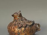 a brown vase with a bird sitting on top of it