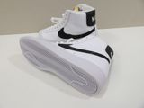 a pair of white sneakers on a white table