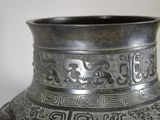 a metal vase with a design on the outside of it