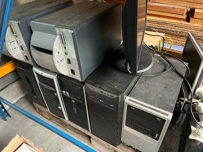 several old computers sitting on top of each other in a warehouse