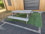 une table de pique-nique et un banc devant un immeuble
