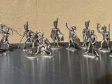 silver figurines of soldiers with spears and shields on a table
