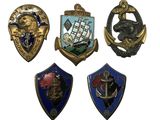 On voit ici quatre insignes de types et de formes différents