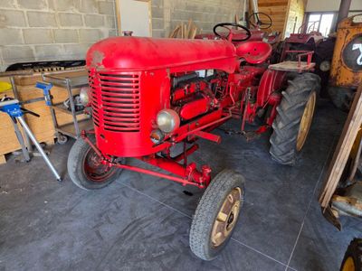 a red tractor that is parked in a garage