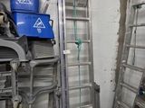 a room with a bunch of ladders and a blue bucket on the floor
