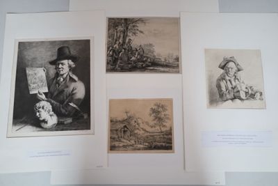 three framed pictures of a man holding a map and a woman holding a skull