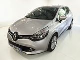 La voiture argentée est garée sur le sol blanc de la pièce.