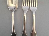 trois cuillères en argent et deux fourchettes en argent sur une table