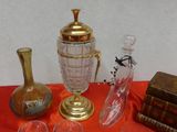 many glasses and vases on a table with a red table cloth