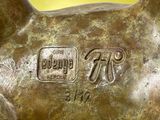 a bronze statue of a dog with a tag on it