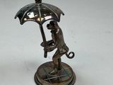 a statue of a man holding an umbrella on a table