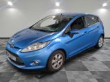 une ford fiesta bleue garée sur un sol en damier dans un garage