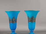 une paire de vases en verre bleu ornés de motifs dorés
