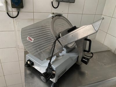 une photo d'une trancheuse à viande posée sur un plan de travail dans une cuisine